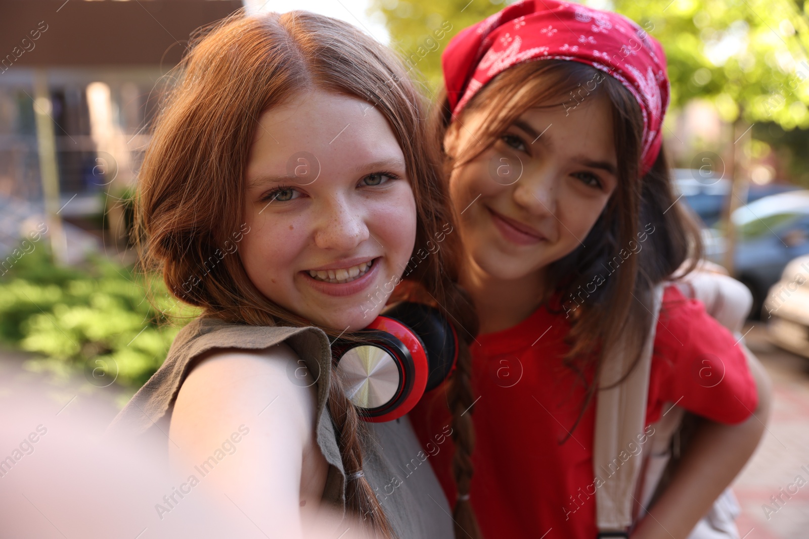 Photo of Happy teenage friends taking selfie on city street