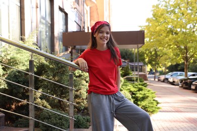 Photo of Happy teenage girl posing on city street