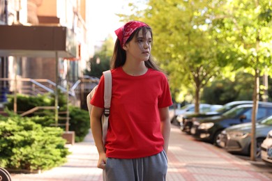 Cute teenage girl walking on city street