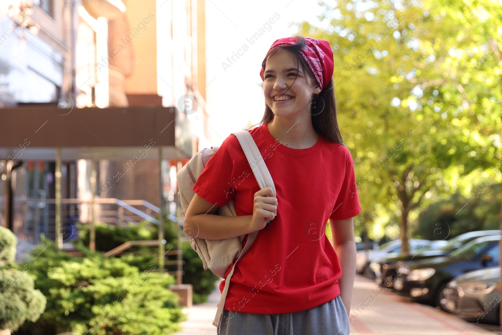 Photo of Smiling teenage girl walking on city street