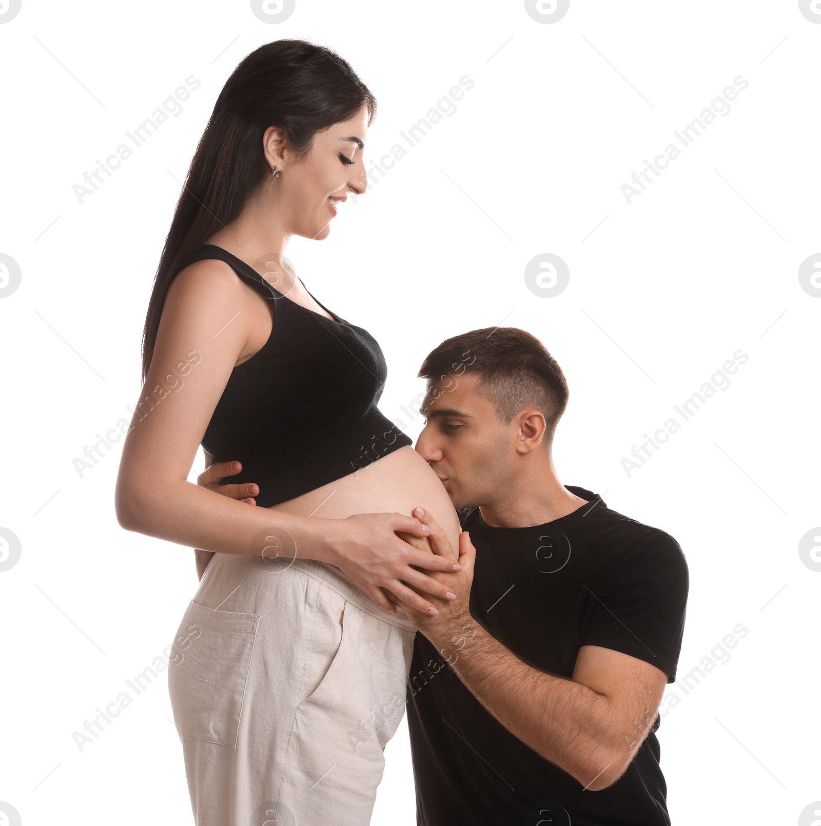 Photo of Man kissing pregnant wife's belly on white background