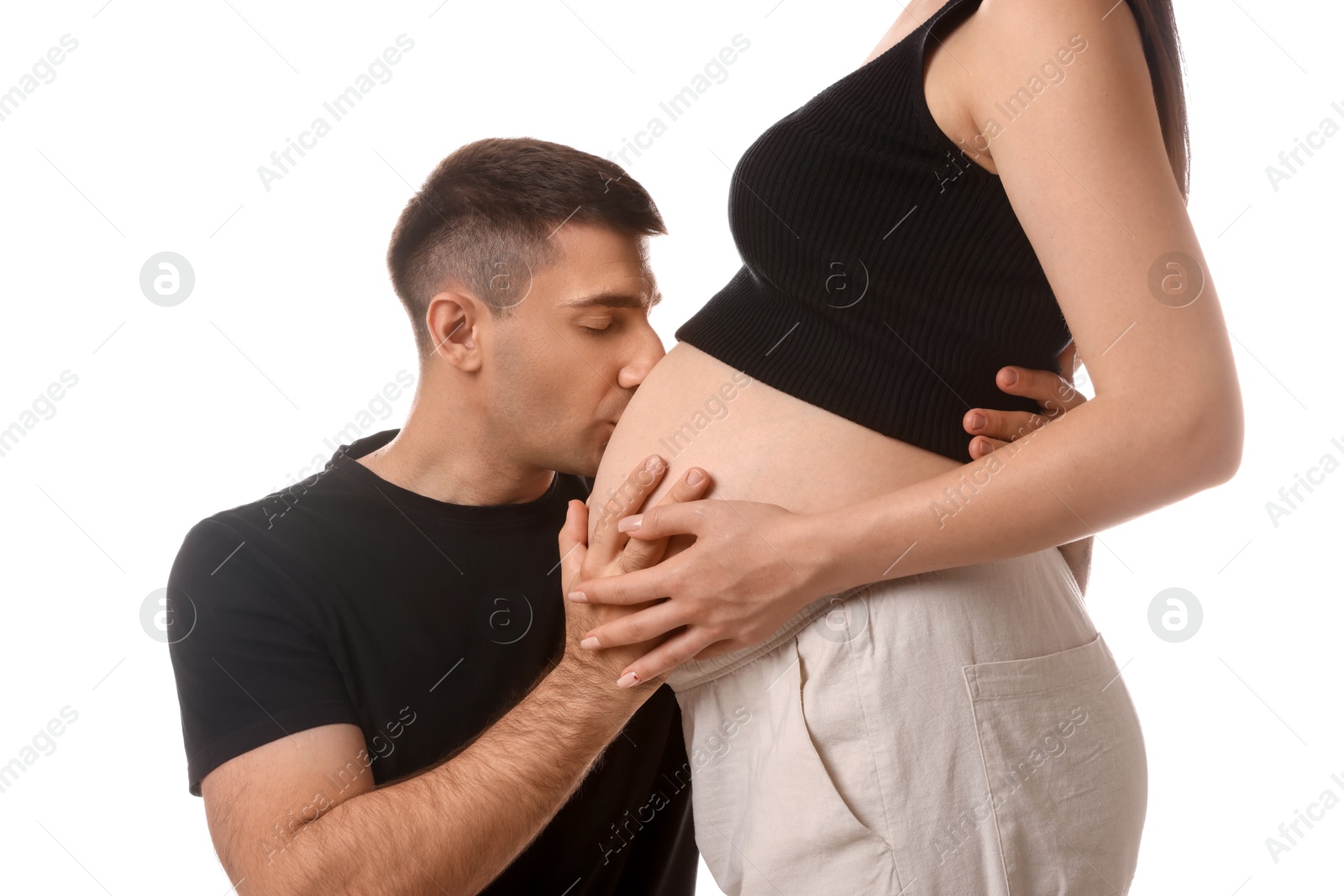 Photo of Man kissing pregnant wife's belly on white background