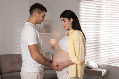 Photo of Beautiful pregnant woman with her husband at home