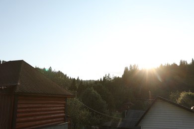 Photo of Beautiful village surrounded by green forest on sunny day