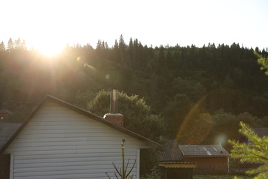 Photo of Beautiful village surrounded by green forest on sunny day