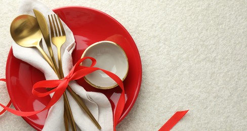 Photo of Christmas table setting with bowl, plate and cutlery, top view. Space for text