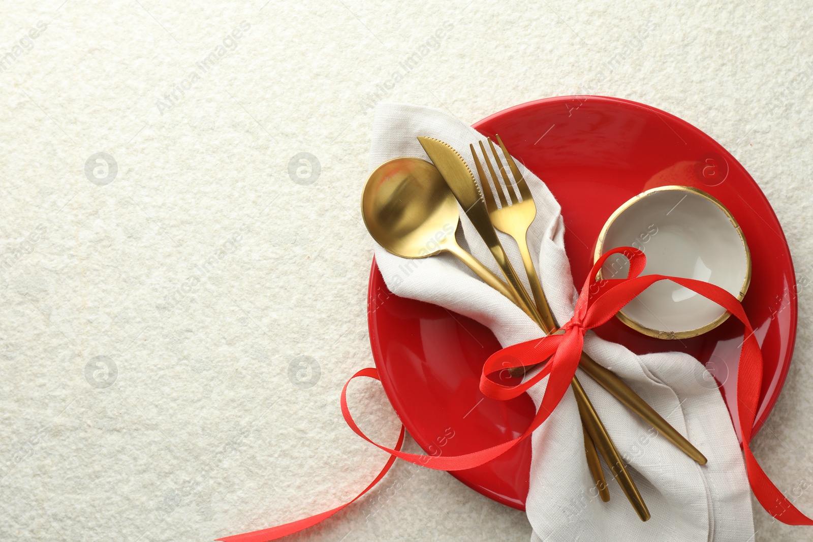 Photo of Christmas table setting with bowl, plate and cutlery, top view. Space for text