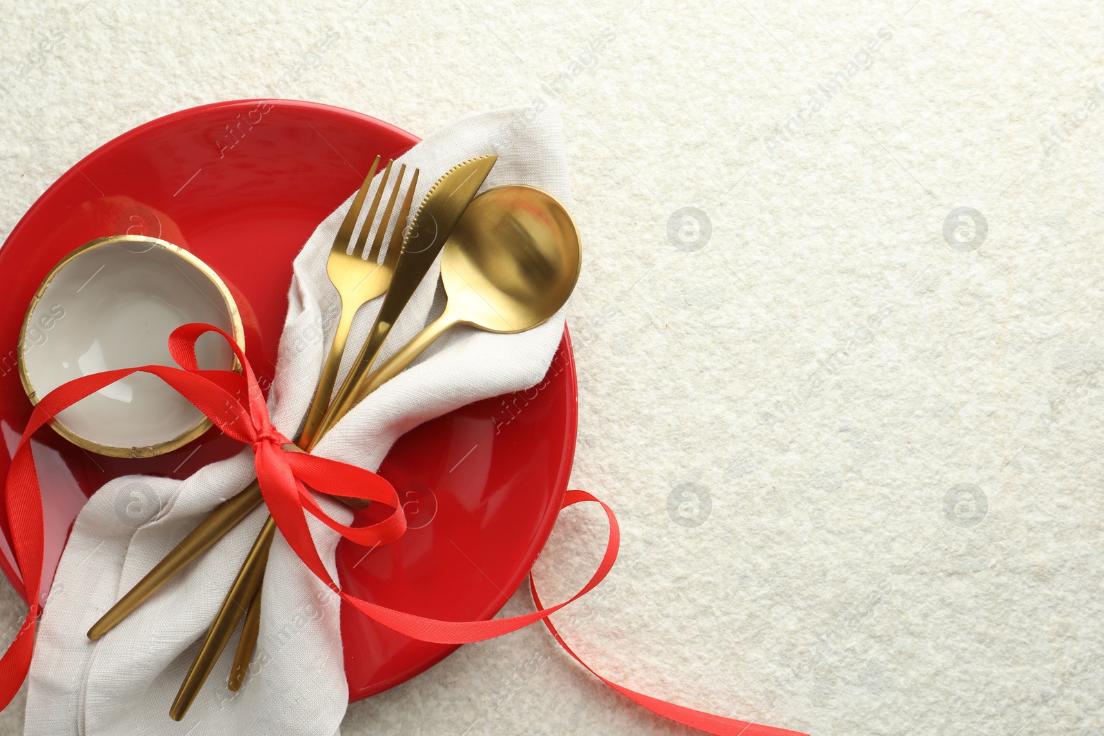 Photo of Christmas table setting with bowl, plate and cutlery, top view. Space for text