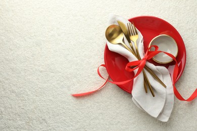 Photo of Christmas table setting with bowl, plate and cutlery, top view. Space for text