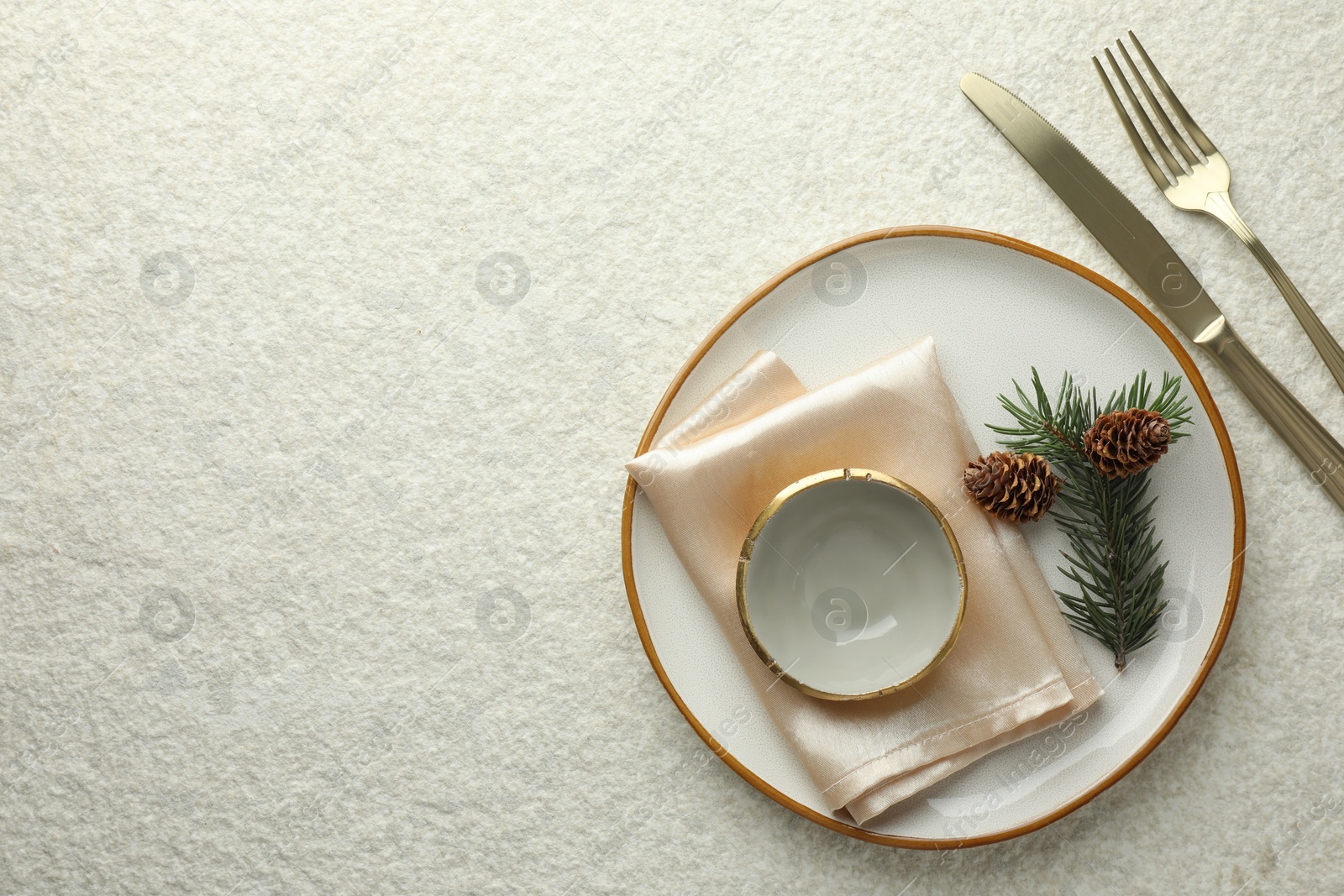 Photo of Christmas table setting with plate, bowl, cutlery, fir branches and cones, flat lay. Space for text