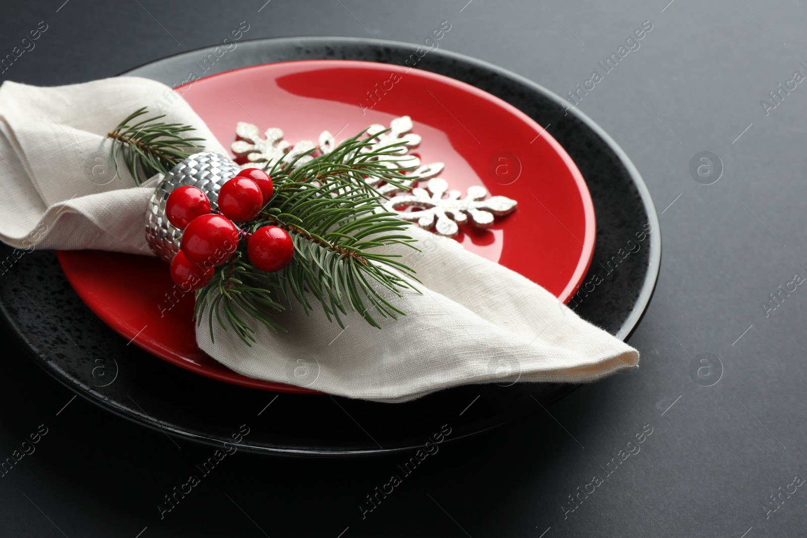 Photo of Christmas setting with festive decor on dark table, closeup