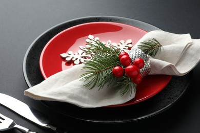 Photo of Christmas setting with festive decor on dark table, closeup