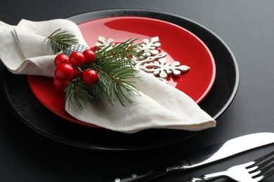 Photo of Christmas setting with festive decor on dark table, closeup