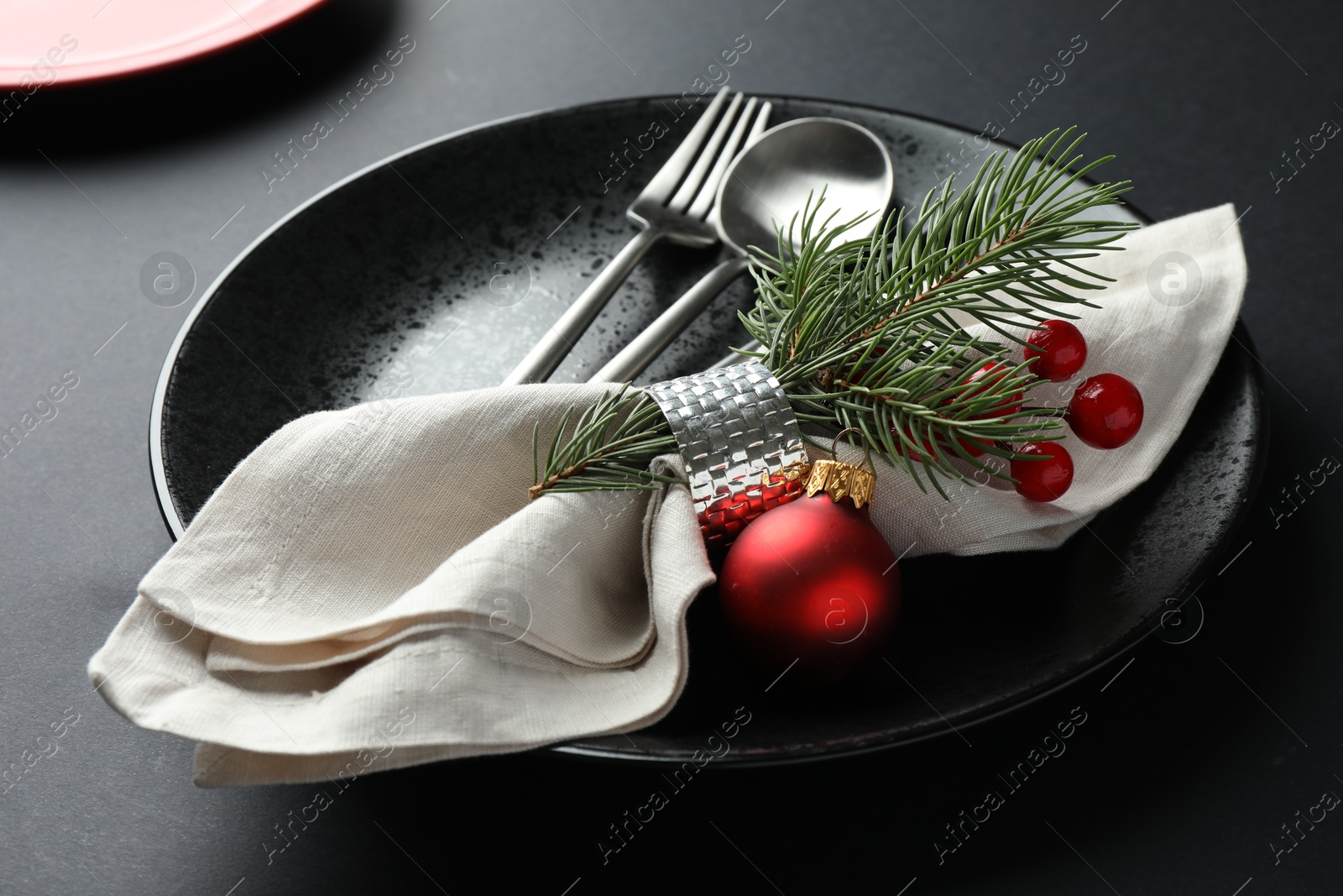 Photo of Christmas setting with festive decor on dark table, closeup