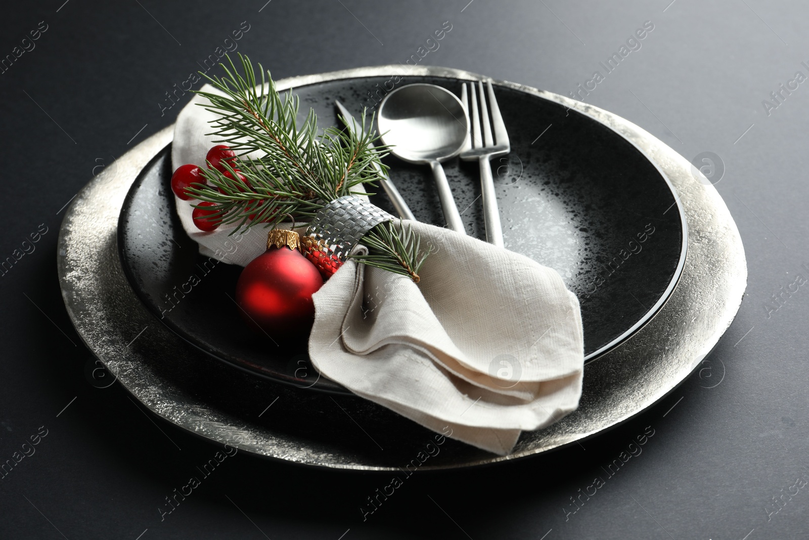 Photo of Christmas setting with festive decor on dark table, closeup