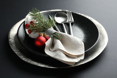 Photo of Christmas setting with festive decor on dark table, closeup