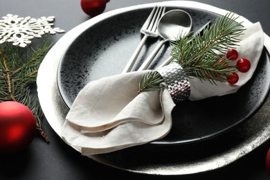 Photo of Christmas setting with festive decor on dark table, closeup