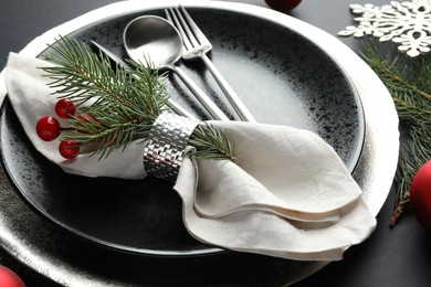 Photo of Christmas setting with festive decor on dark table, closeup