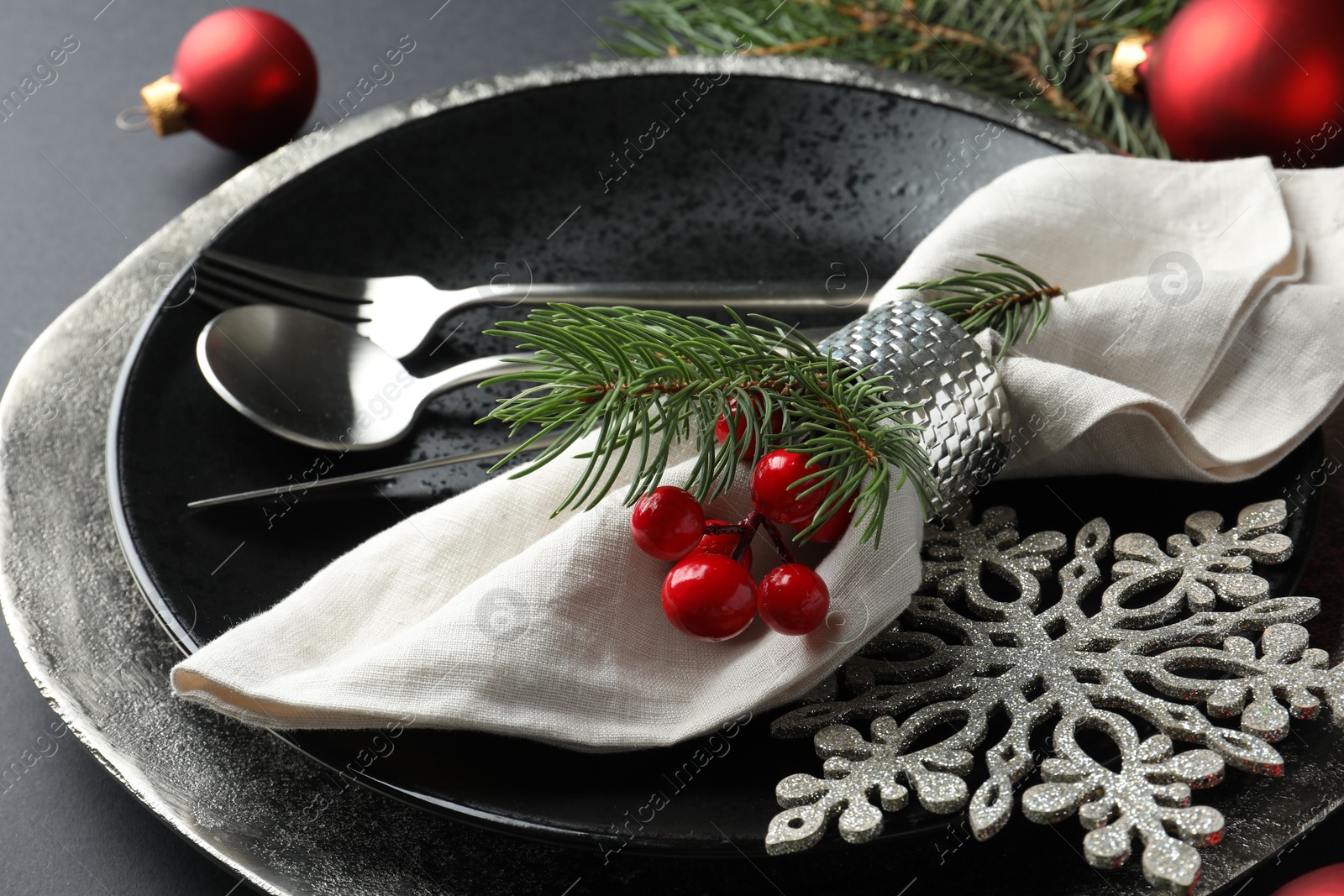 Photo of Christmas setting with festive decor on dark table, closeup