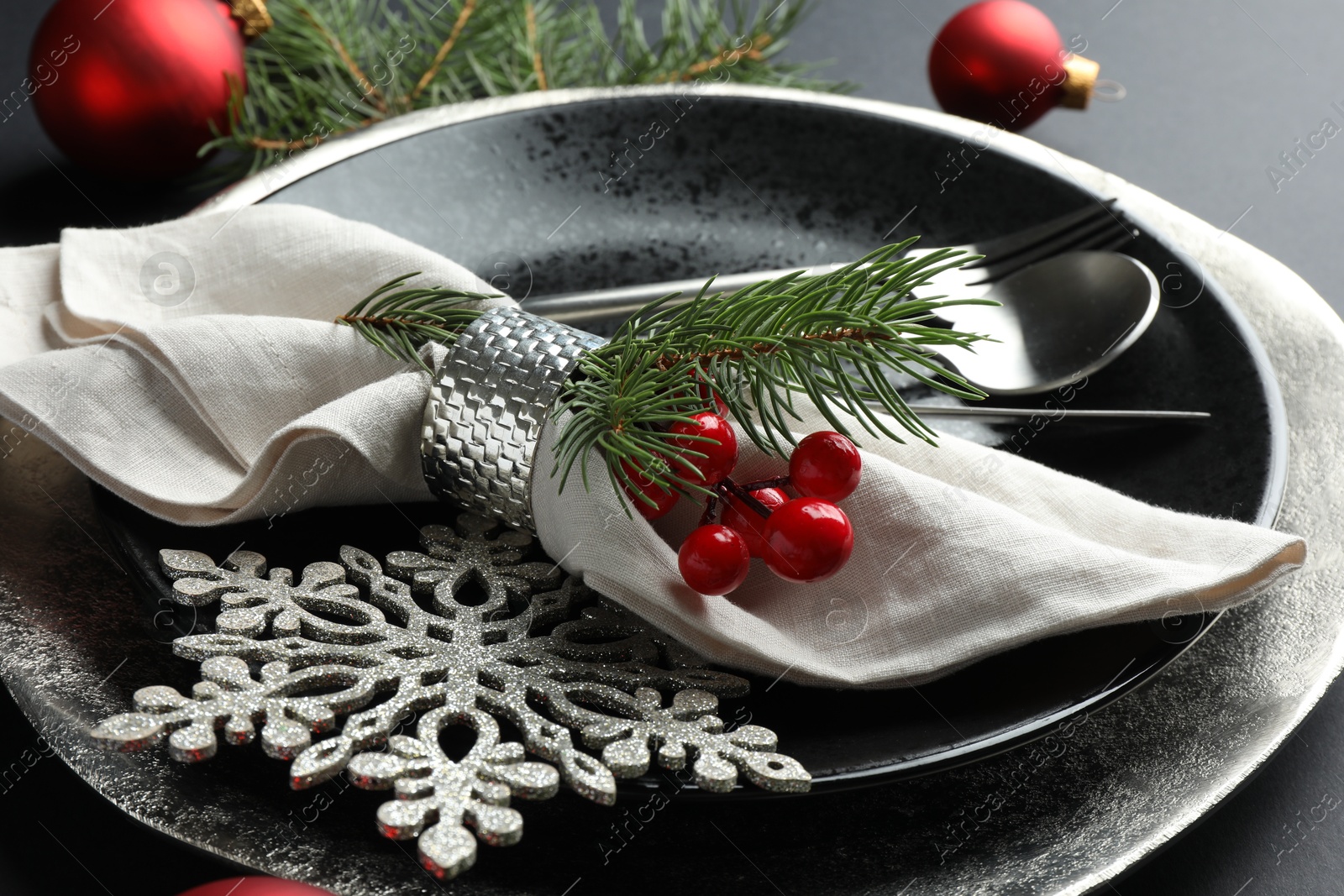 Photo of Christmas setting with festive decor on dark table, closeup