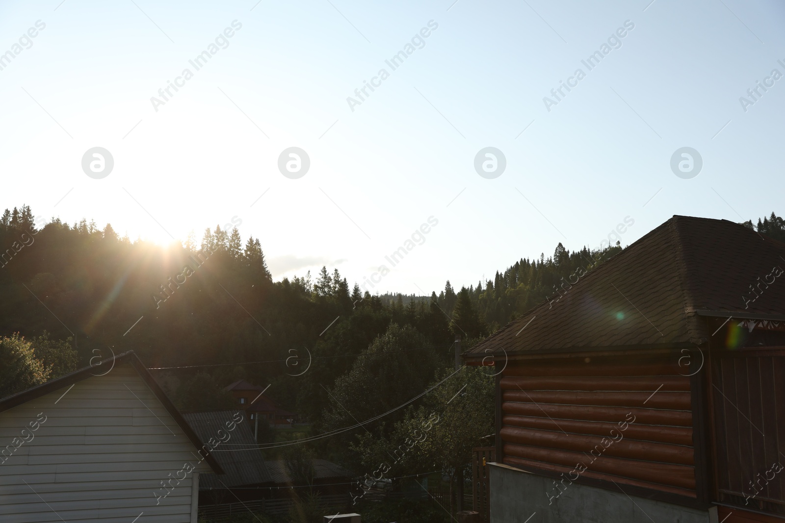 Photo of Beautiful village surrounded by green forest on sunny day