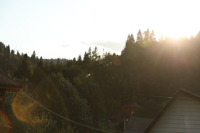 Photo of Beautiful village surrounded by green forest on sunny day