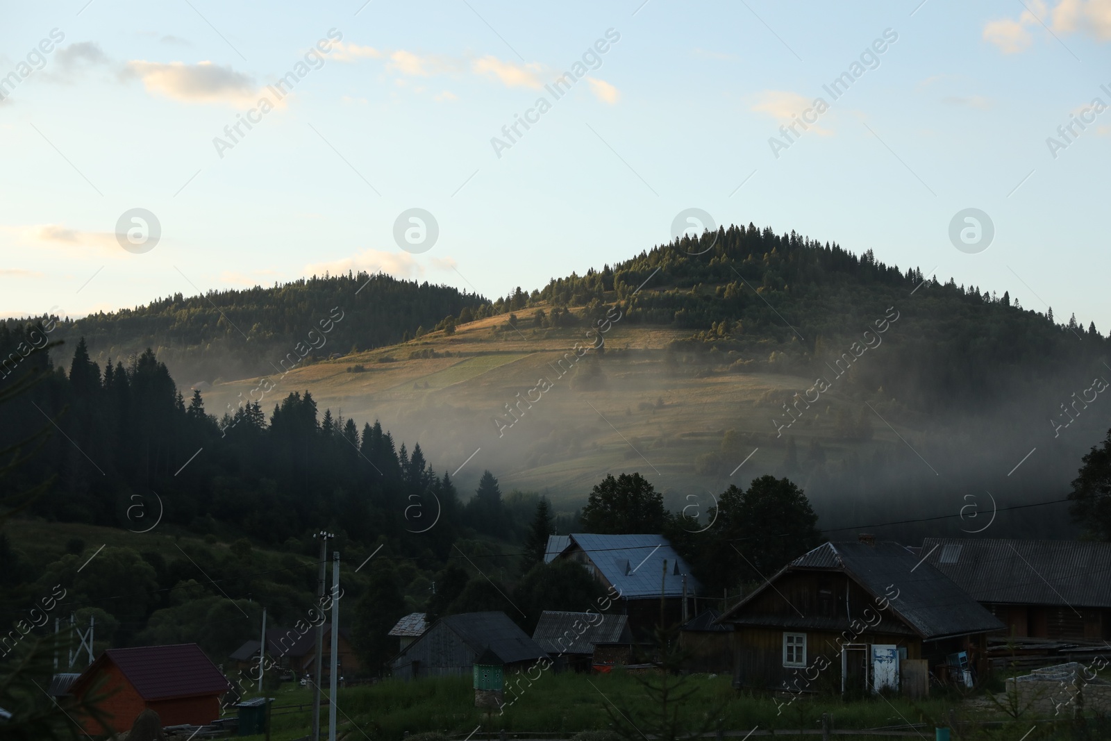 Photo of Picturesque view of fog covering mountain village in morning