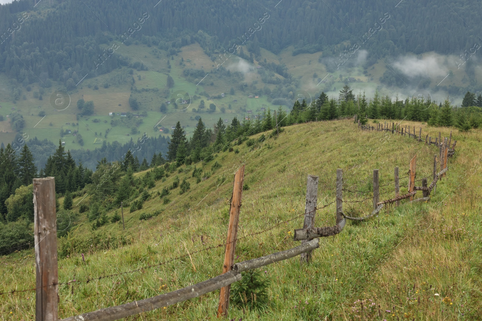 Photo of Picturesque view of beautiful mountains and wooden fence