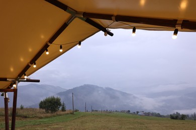 Photo of Roof of building with decorative lights in mountains