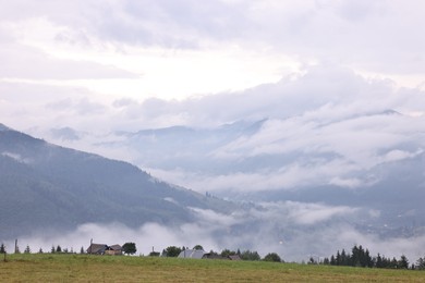 Picturesque view of beautiful mountains covered with fog