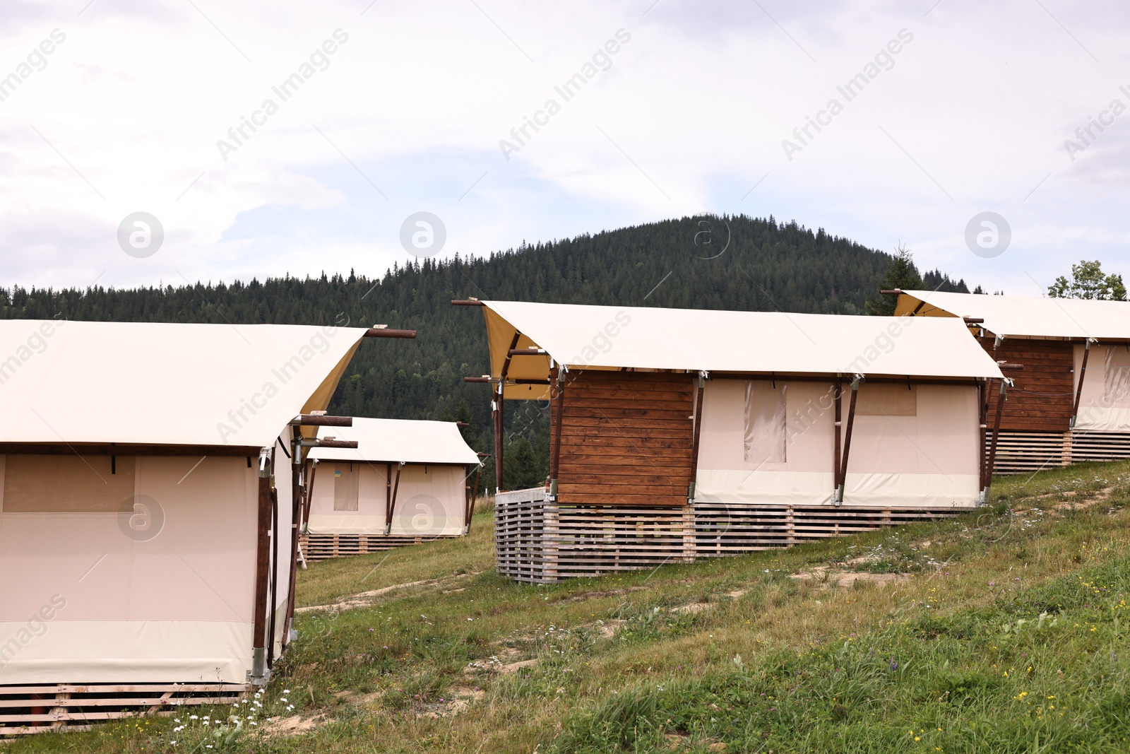 Photo of Green forest and many houses in mountains. Glamping site