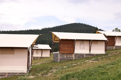 Green forest and many houses in mountains. Glamping site