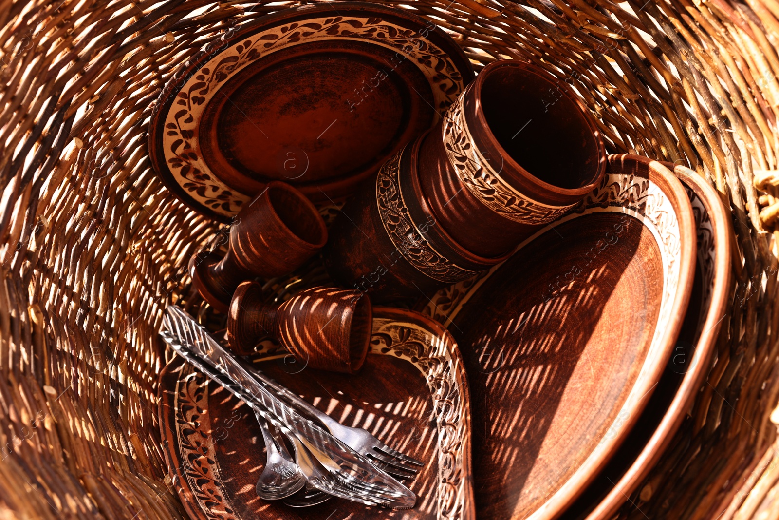 Photo of Wicker basket with different cutlery and tableware, top view