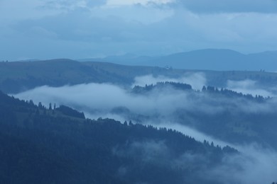 Photo of Picturesque view of beautiful mountains covered with fog