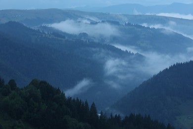 Photo of Picturesque view of beautiful mountains covered with fog