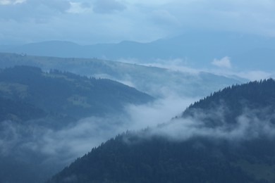 Photo of Picturesque view of beautiful mountains covered with fog