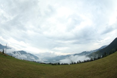 Photo of Picturesque view of beautiful mountains covered with fog. Fisheye lens effect