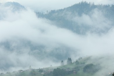 Photo of Picturesque view of beautiful mountains covered with fog