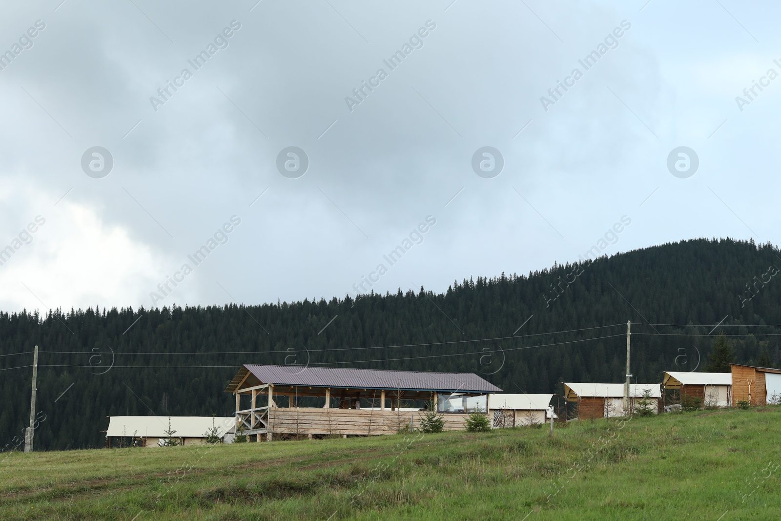 Photo of Many buildings in mountains at summer. Glamping site