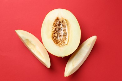 Fresh cut melon on red background, flat lay