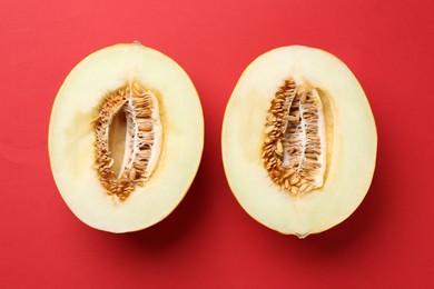 Photo of Halves of fresh melon on red background, top view