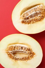 Halves of fresh melon on red background, top view