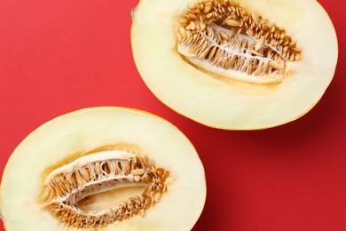 Halves of fresh melon on red background, top view