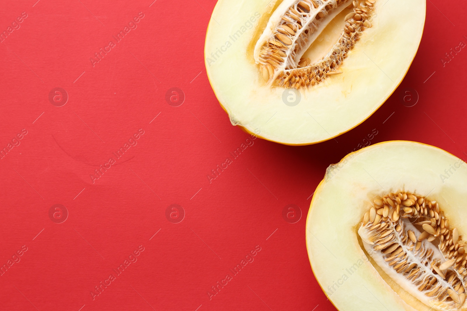 Photo of Halves of fresh melon on red background, top view. Space for text