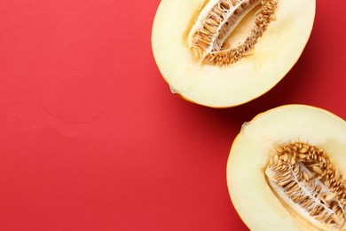 Halves of fresh melon on red background, top view. Space for text