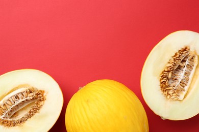 Photo of Whole and halves of fresh melon on red background, flat lay. Space for text