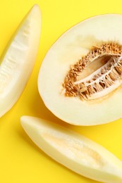 Photo of Fresh cut melon on yellow background, flat lay