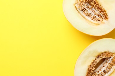 Photo of Halves of fresh melon on yellow background, top view. Space for text