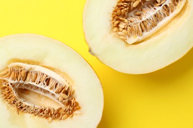 Halves of fresh melon on yellow background, top view