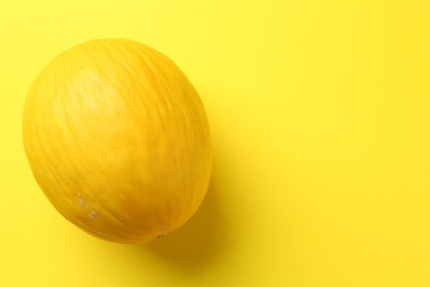 Photo of One fresh melon on yellow background, top view. Space for text